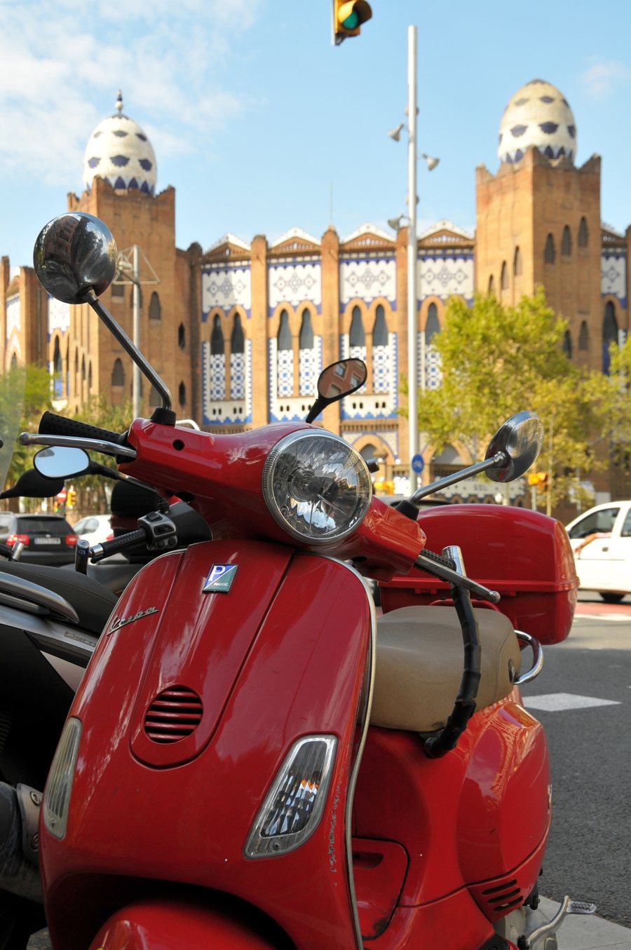 Rote Vespa vor einer verzierten Fassade in Barcelona